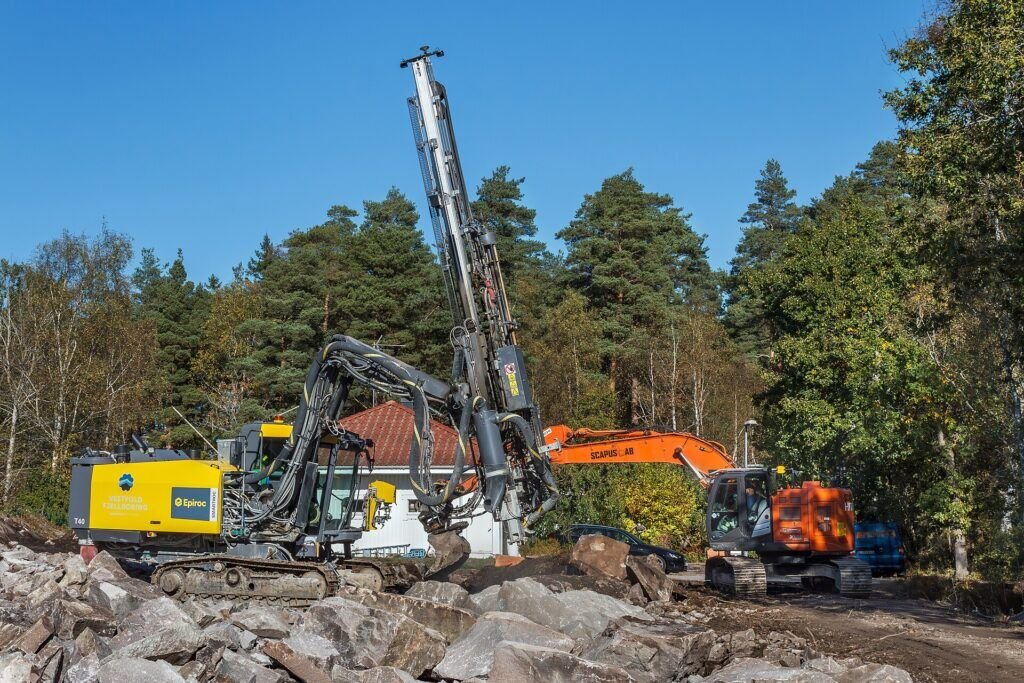 Drilling rig dan excavator bekerja bersama di lokasi konstruksi