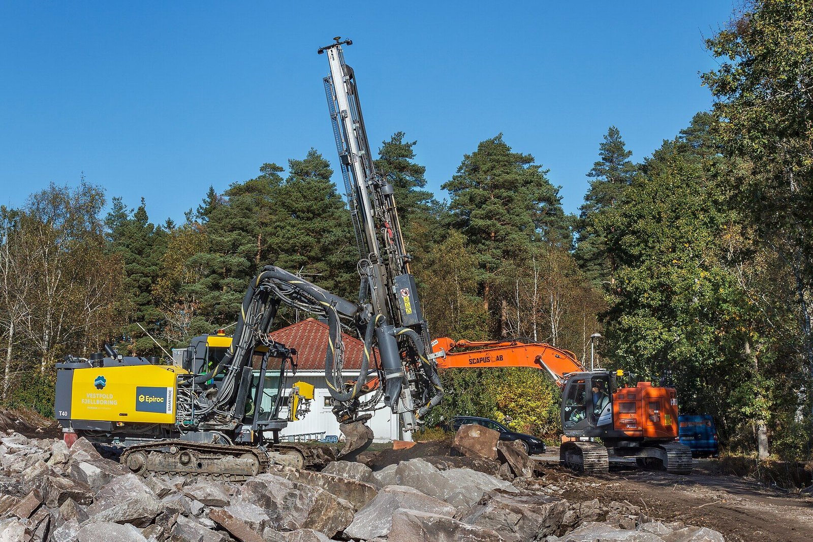 Drilling rig dan excavator bekerja bersama di lokasi konstruksi